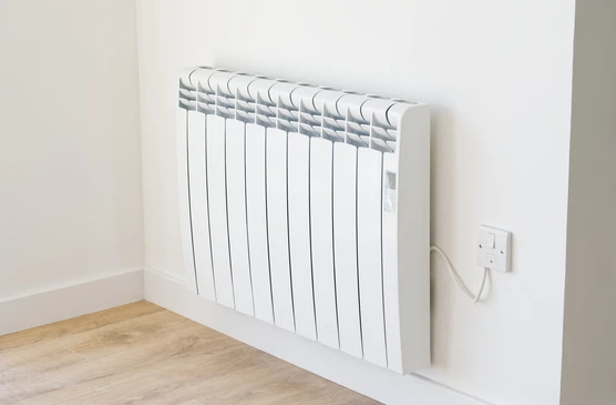 Intérieur résidentiel moderne avec radiateur électrique blanc à inertie installé contre mur blanc