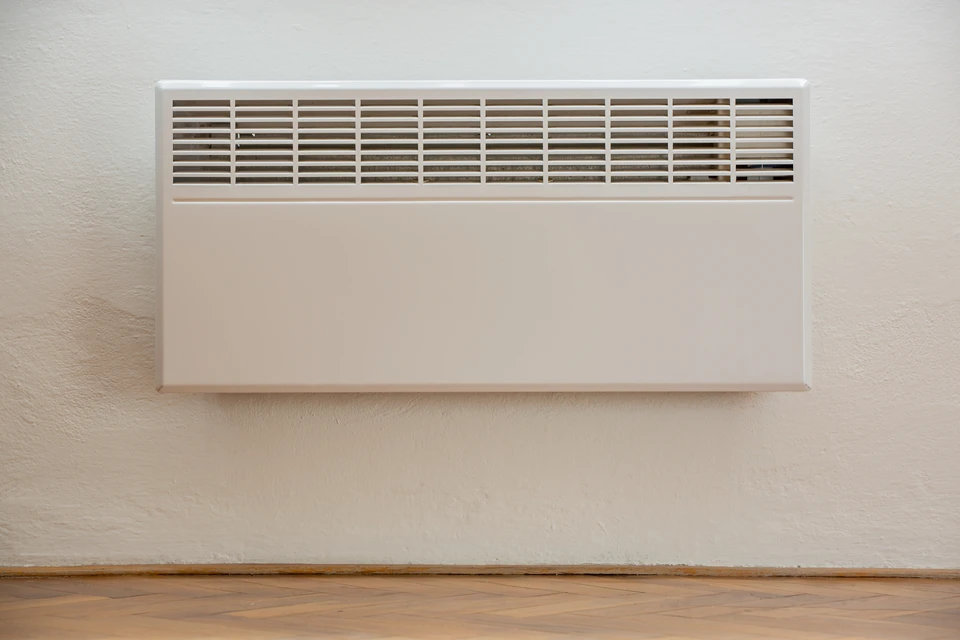 Intérieur résidentiel moderne avec radiateur électrique blanc à inertie installé contre mur blanc